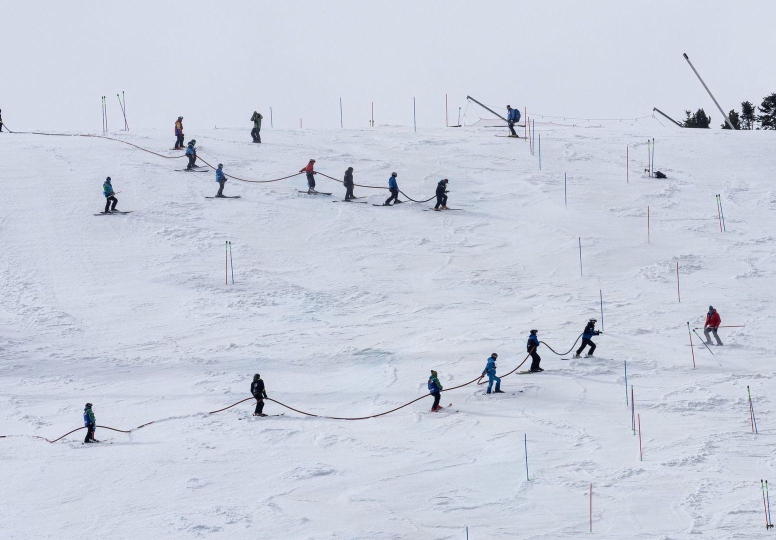 Young skiers practice on a snowy slope using a rope tow